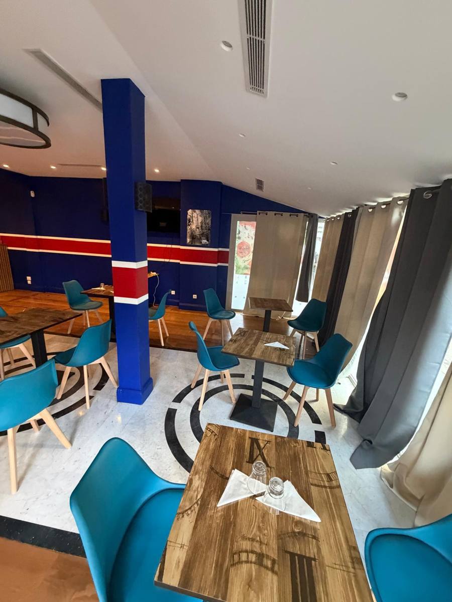La salle de La cuisine du Murat, boulevard Murat à Paris : chaises bleues, tables en bois et murs bleu, blanc, rouge